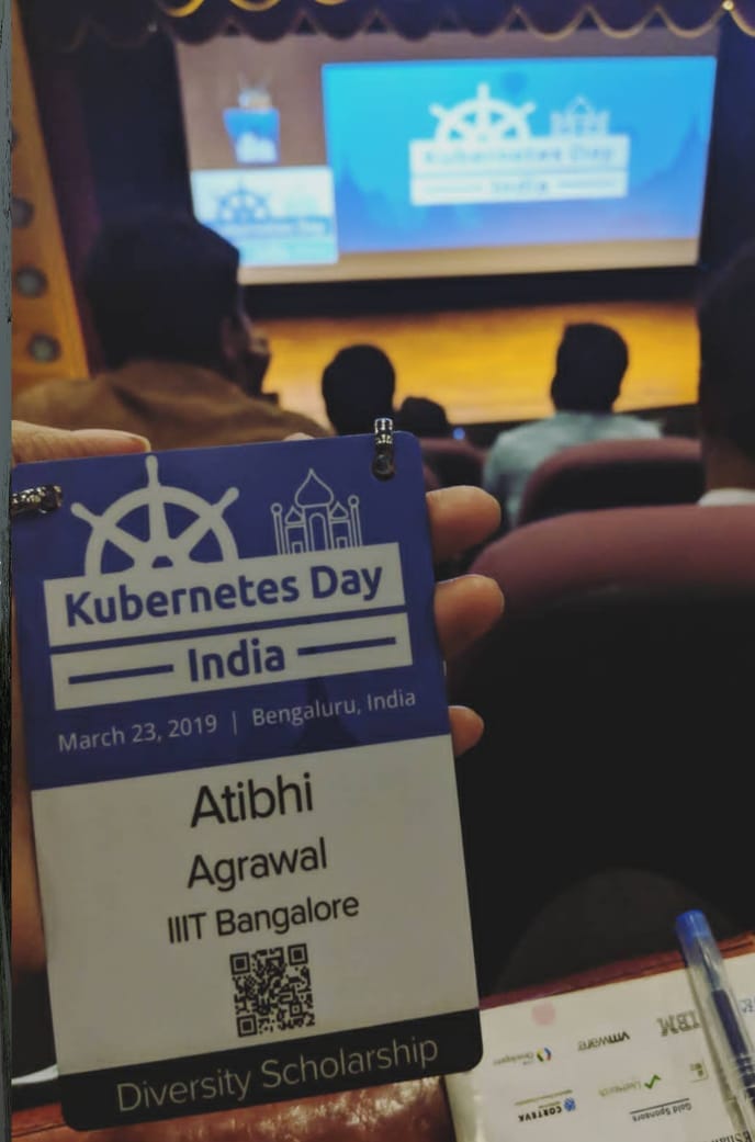 Kubernetes Day India, March 23, 2019 name tag of Atibhi Agrawal IIIT Bangalore held facing the stage in conference room